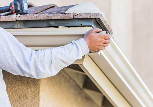 Workers installed new K-style seamless gutters on the fascia of a home